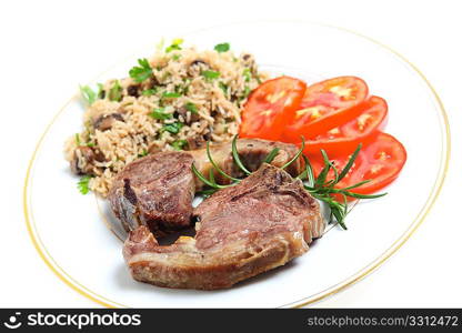 Two grilled lamb chops with mushroom rice (pilau) and sliced tomato.