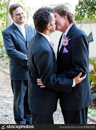 Two grooms kiss eachother in front of the minister at their gay marriage ceremony.&#xA;