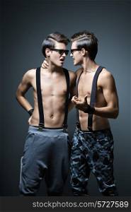 Two guys in the pants with suspenders on a dark blue background