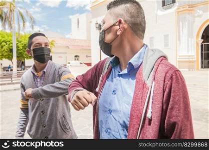 Two guys shaking elbows, two men wearing face masks shaking elbows, elbow shaking concept