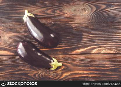 Two halves of aubergine on the wooden background: top view