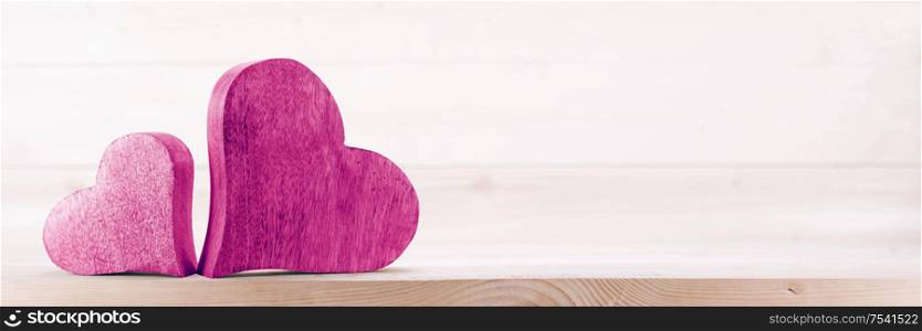 Two handmade wooden carved hearts on light wood background couple relationship Valentine day concept. Two wooden hearts