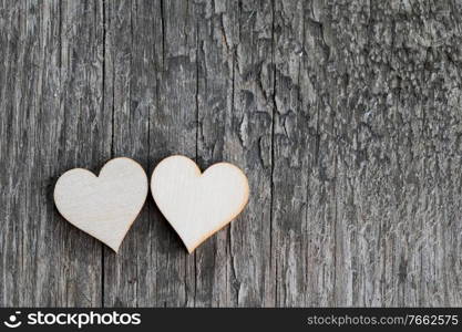 Two handmade wooden carved hearts on wood background couple relationship Valentine day concept. Two wooden hearts