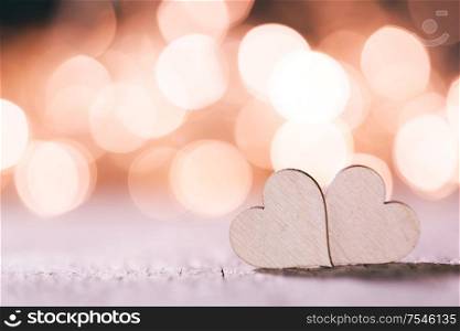 Two handmade wooden hearts on beautiful pink bokeh background. Vintage style. Love Valentine&rsquo;s Day concept.. Two hearts on bokeh background