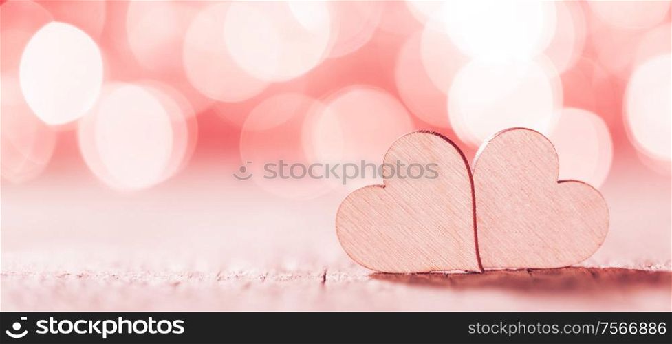 Two handmade wooden hearts on beautiful pink bokeh background. Vintage style. Love Valentine&rsquo;s Day concept.. Two hearts on bokeh background