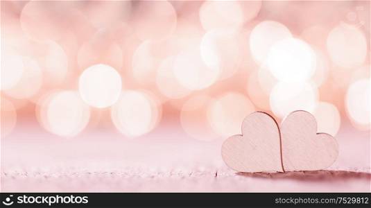 Two handmade wooden pink hearts on beautiful bokeh background. Vintage style. Love Valentine&rsquo;s Day concept.. Two pink hearts on bokeh background