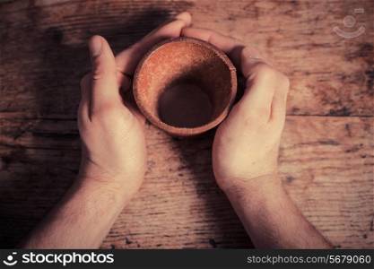 Two hands are holding a leather dice cup at a table