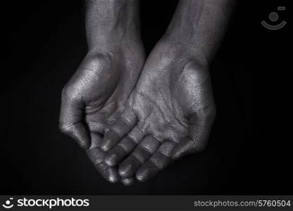 Two hands folded a handful on a black background