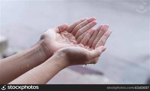 two hands holding falling rain, rainy day, stormy season, Catches rains on Palm, rainy season slow motion, on the street side, air moist condensation, acid rain measurement, isolated close up