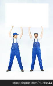 Two handsome builders holding a banner