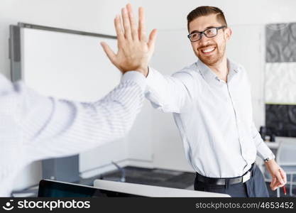 Two handsome businessmen in office. Two handsome businessman in office celebrating victory