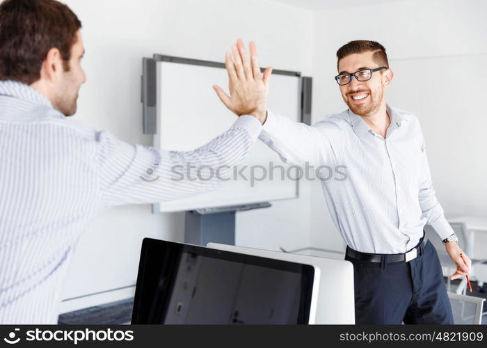 Two handsome businessmen in office. Two handsome businessman in office celebrating victory