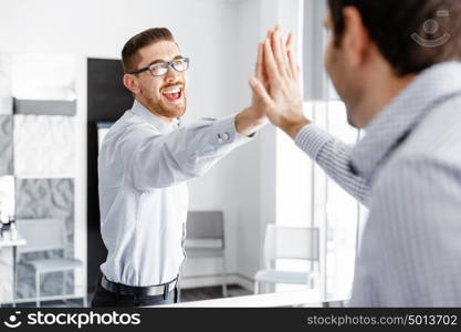 Two handsome businessmen in office. Two handsome businessman in office celebrating victory