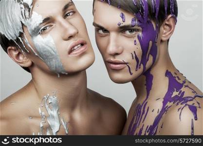 two handsome men in silver and violet paint