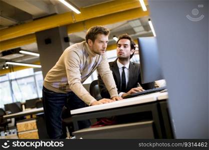 Two handsome young businessmen discussing in office by the table