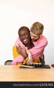 Two happy affectionate young female hugging each other in a close embrace while laughing and smiling, young multiracial female friends