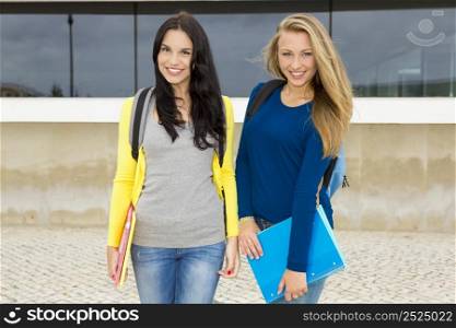 Two happy and beautiful teenage students in the school