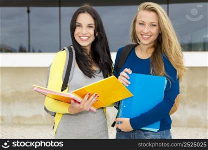 Two happy and beautiful teenage students in the school