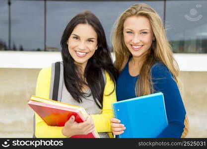 Two happy and beautiful teenage students in the school