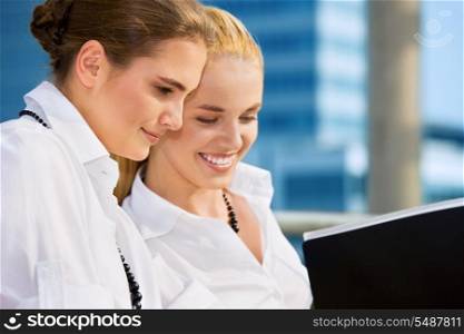 two happy businesswomen with documents (focus on brunette)