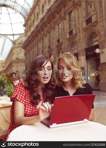 two happy businesswomen with laptop computer in the city