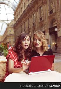 two happy businesswomen with laptop computer in the city