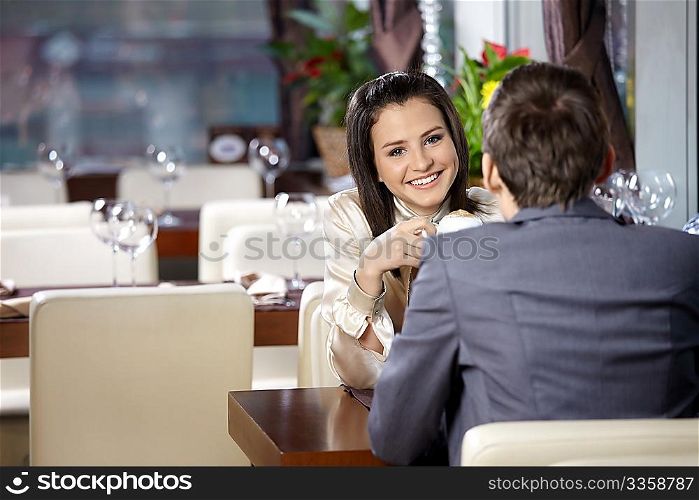 Two happy enamoured sit at restaurant