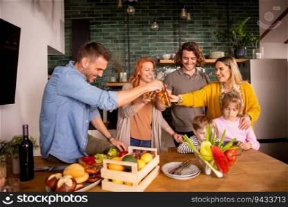 Two happy families toasting with cider while preparing dinner in the kitchen