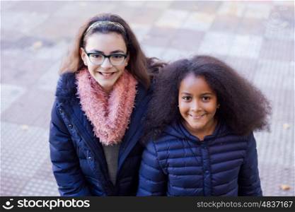 Two happy girls at the street with coats