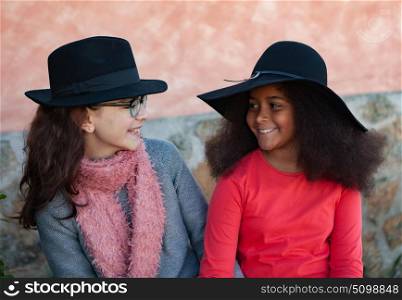 Two happy girls friends with stylish hats lauging