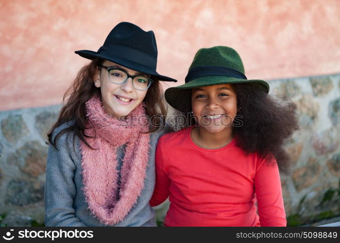 Two happy girls friends with stylish hats lauging