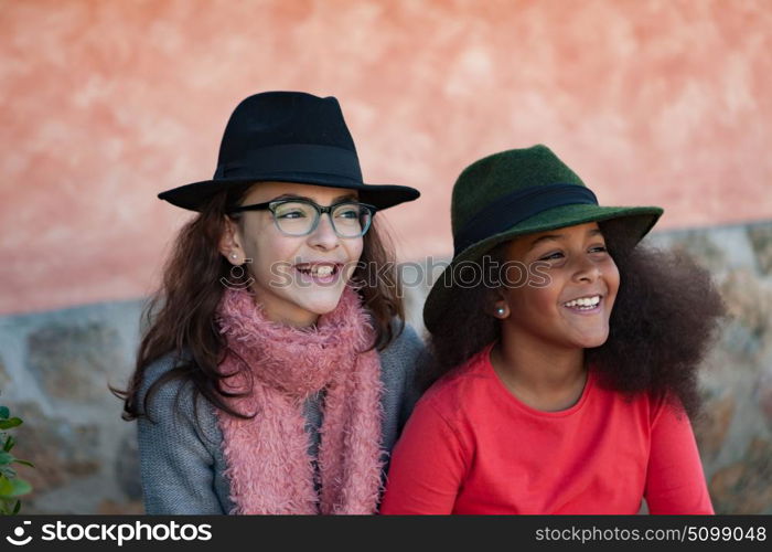 Two happy girls friends with stylish hats lauging