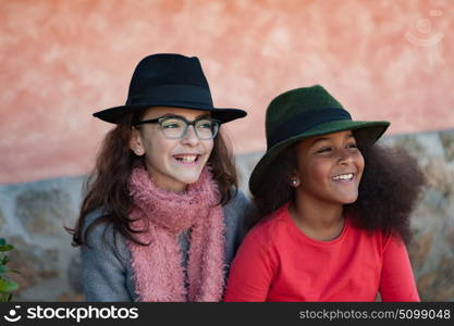 Two happy girls friends with stylish hats lauging