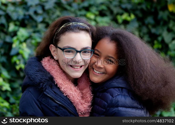 Two happy girls in the park with coats