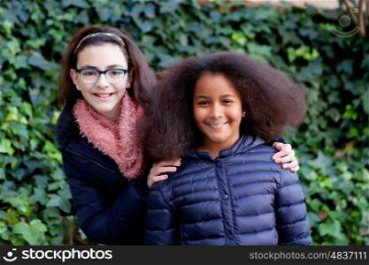 Two happy girls in the park with coats