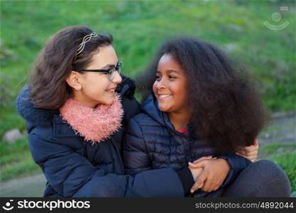 Two happy girls in the park with coats
