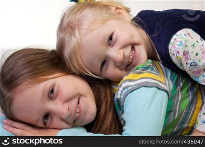 two happy little smiling sisters embracing