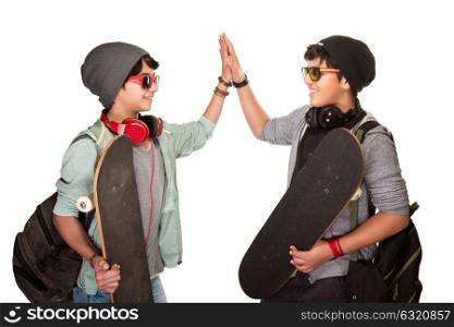 Two happy skateboarders acclaiming each other isolated on white background, best friends wearing stylish hats, sunglasses and listening music from earphone, modern life of a young people