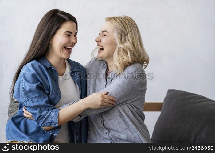 two happy women smiling embracing each other