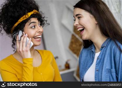 two happy women smiling talking phone