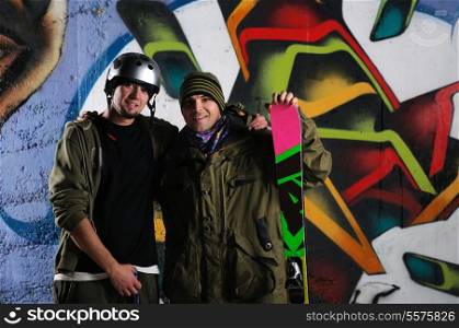 two happy young skiirs standing against colorful background