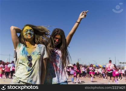 two happy young women enjoying dancing holi festival