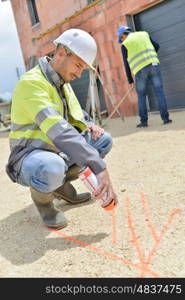 two hard working builders in uniforms putting pavement