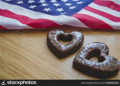 two heart shaped biscuits and usa flag on wooden table - happy memorial day.. two heart shaped biscuits and usa flag on wooden table happy memorial day.