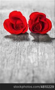 Two heart shaped red roses on wooden background, Valentines day