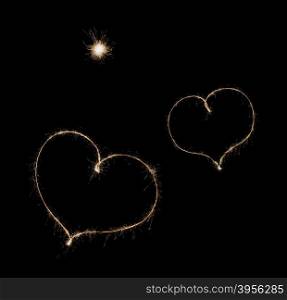 two hearts from sparkler on black background