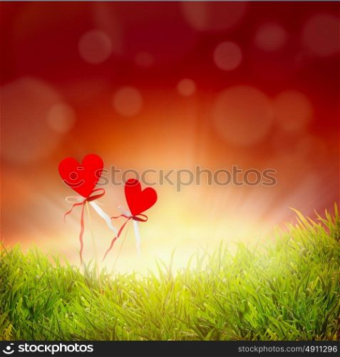 Two hearts on grass and sky background with bokeh, abstract love concept