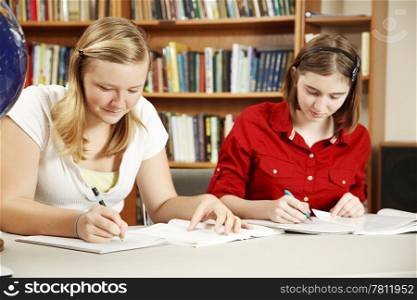 Two high school students doing their homework in the library.