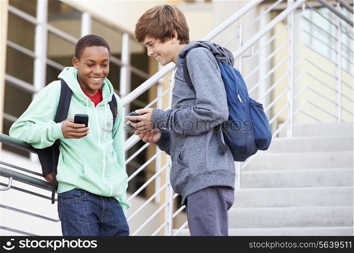 Two High School Students Outside Building With Mobiles