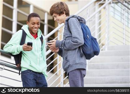 Two High School Students Outside Building With Mobiles